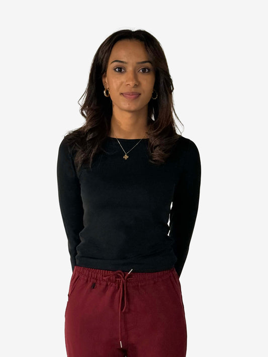 Veterinary professional wearing black Nila underscrubs made with Avestra™ performance fabric in a hospital setting.