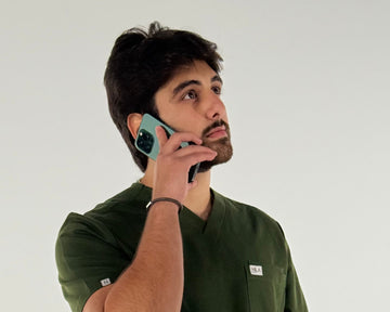 doctor wearing nila scrubs in forest gree speaking to a patient 