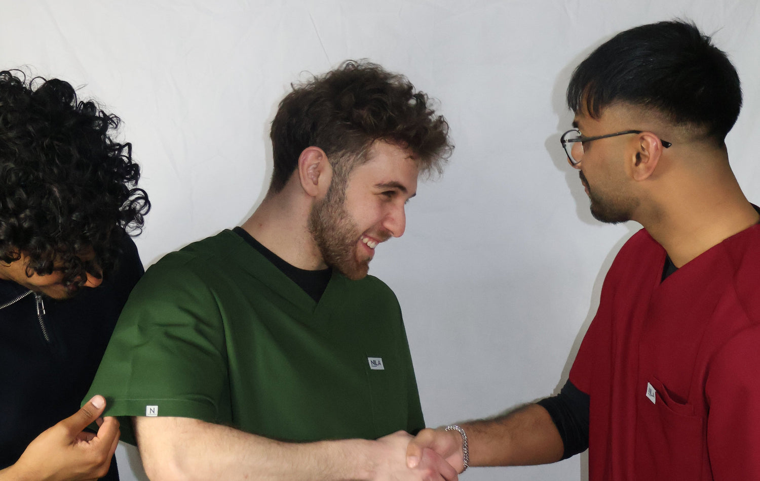 founders of nila scrubs wearing nila scrubs set for men in wine red and forest green