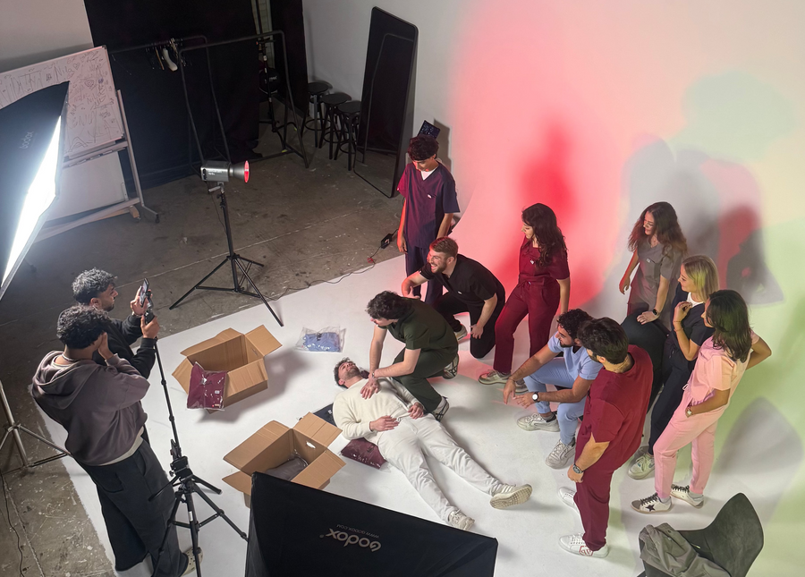 group of doctors treating a patient in nila scrubs, in a medical center